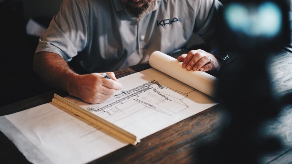 7 Motivos para Aplicar o Feng Shui no Projeto de Arquitetura 51 Arquiteto desenhando sobre a mesa.
