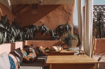 O melhor dessa tendência é que combina perfeitamente com materiais naturais, como vime e palha (falamos sobre a alta desses materiais no conteúdo sobre Grandmillennial Style). Nos “souks” (lojas tradicionais da região) de Marrakech, é possível encontrar todo tipo de decoração artesanal, como abajures e itens para mesa, além de diversas opções de tapetes e almofadas. Essa cultura rica em cores e detalhes tornou-se inspiração para transformar os ambientes neutros de maneira fácil e com resultado imediato.